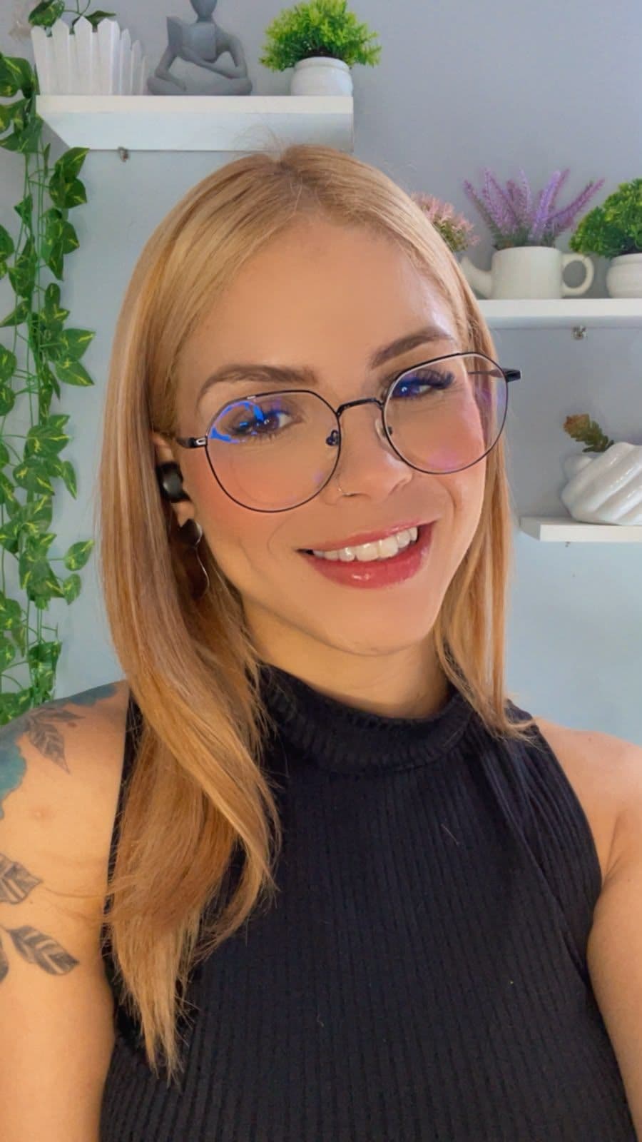 Naila Rayanne sorrindo, de óculos e fone de ouvido, pronta para uma sessão por videochamada